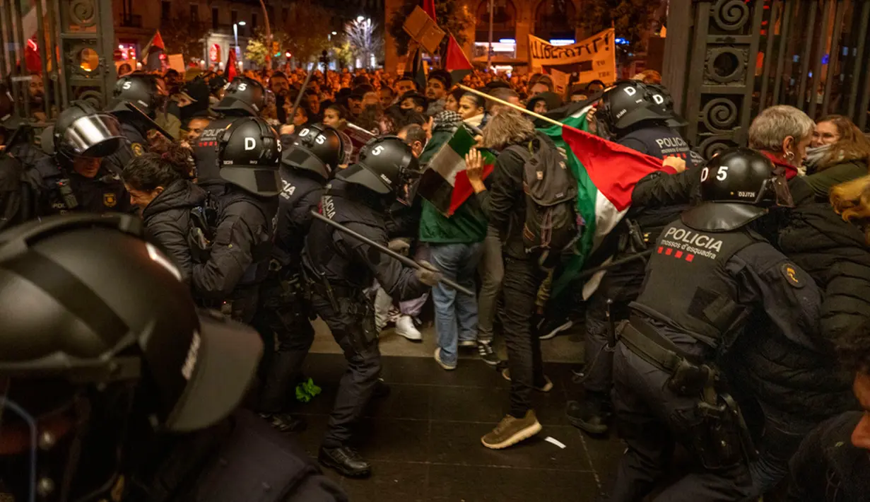 Dalam aksi itu, massa mengibarkan bendera Palestina sebagai bentuk dukungan untuk warga Palestina yang sedang dibombardir Israel. (AP Photo/Emilio Morenatti)