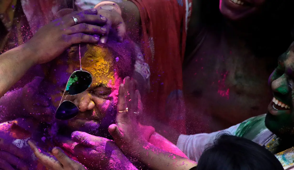 Wajah seorang pria diolesi bubuk berwarna saat Festival Holi di Mumbai, India, Selasa (10/3/2020). Festival Holi menandai datangnya musim semi di India. (AP Photo/Rajanish Kakade)