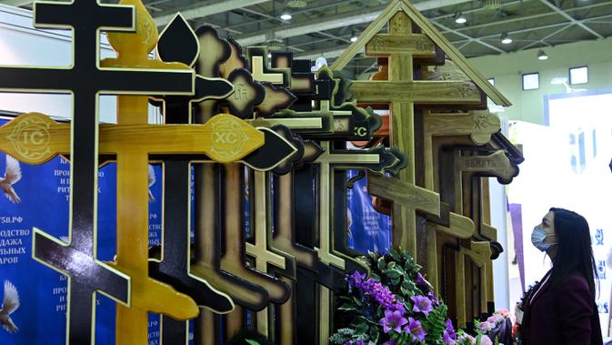 Seorang peserta melihat salib selama pameran pemakaman di Moskow, Rusia pada Rabu (21/10/2020). (Photo by Kirill KUDRYAVTSEV / AFP)