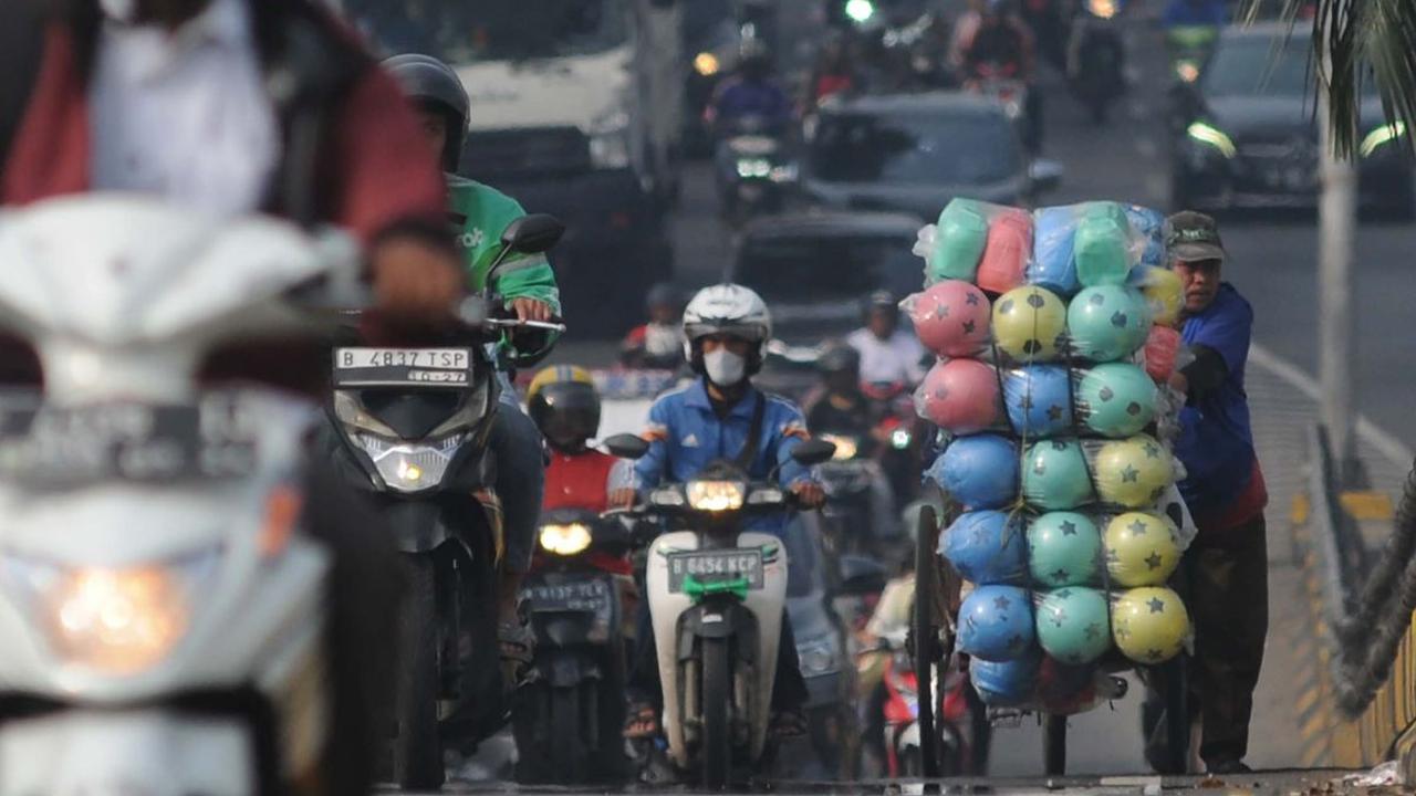 Seorang pedagang keliling mendorong gerobaknya dengan berjalan kaki saat melewati flyover di Buaran, Jakarta, Kamis (2/5/2024). Flyover Buaran sangat berbahaya bagi pejalan kaki. Pasalnya, jalan layang ini tak dilengkapi ruang bagi pejalan kaki, baik itu 