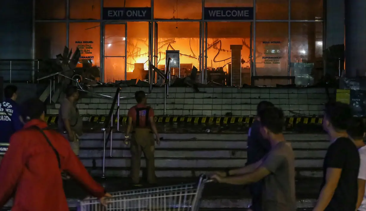 Kondisi gedung pusat perbelanjaan atau Mal di kota Davao saat dilanda kebakaran, Filipina selatan (23/12). Kebakaran ini terjadi hampir bersamaan dengan badai tropis yang mengakibatkan banjir di wilayah Filipina Selatan. (AFP Photo / Manman Dejeto)