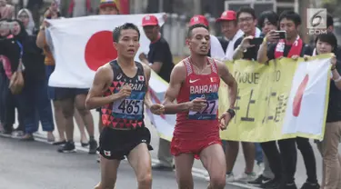 Pelari maraton Jepang, Hiroto Inoue bersaing dengan Elhassan Elabbassi dari Bahrain saat memasuki garis finis lomba Asian Games 2018 di jalan Sudirman, Jakarta, Sabtu (25/8). Hiroto menjadi pemenang lari maraton 42 kilometer. (Merdeka.com/Imam Buhori)