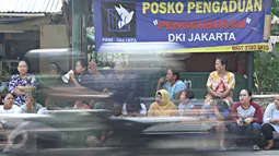 Sejumlah ibu-ibu RT 08/08, Jalan Lauser, Kebayoran Baru, Jakarta, terlihat duduk di tepi jalan, Senin (9/5). Warga melakukan aksi penutupan Jalan Lauser terkait rencana penggusuran dan pelayangan SP-2 tersebut. (Liputan6.com/Immanuel Antonius)