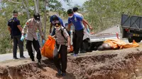 Petugas membawa jenazah korban gempa dan tsunami untuk dimakamkan massal di Palu, Sulawesi Tengah, Senin (1/10). (AP Photo/Tatan Syuflana)