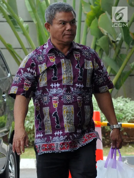 Petugas Pemeriksa Pajak Wilayah Maluku-Papua, Sulimin Ratmin (batik) digiring petugas setibanya di gedung KPK, Jakarta, Kamis (4/10). Sulimin Ratmin terjaring OTT KPK di Ambon dan Papua terkait dengan pengurangan pembayaran pajak (Merdeka.com/Dwi Narwoko)