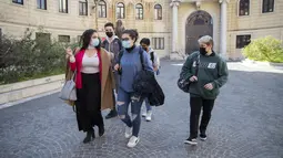 Matteo Coccimiglio (kanan) meninggalkan sekolah seni Ripetta di Roma, 24 Maret 2021. Siswa 18 tahun tersebut mengidentifikasi dirinya sebagai laki-laki, dan sedang dalam proses mengubah status gendernya dari perempuan menjadi pria. (AP Photo/Alessandra Tarantino)