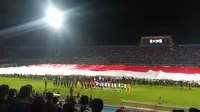 Bendera Merah Putih raksasa berkibar jelang laga Arema FC Vs PSIS Semarang di Stadion Kanjuruhan, Kabupaten Malang, Sabtu (31/8/2019). (Bola.com/Iwan Setiawan)