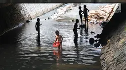 Sejumlah anak bermain sambil mencari ikan di Kali Pancoran, Jakarta, Jumat (14/9). Kondisi kali yang kotor tidak menyurutkan niat anak-anak tersebut untuk tetap bermain, meskipun berbahaya bagi kesehatan mereka. (Liputan6.com/Immanuel Antonius)