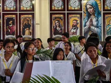Paduan suara gereja Katolik mempersiapkan daun palem selama prosesi untuk menandai Minggu Palem di Gereja Kelahiran Bunda Maria, yang juga dikenal sebagai Gereja Katolik Kelahiran Santa Perawan Maria, di Surabaya pada 13 April 2025. (JUNI KRISWANTO/AFP)