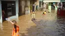 Anak-anak bermain di tengah banjir yang merendam kawasan Rawajati, Jakarta Selatan, Sabtu (8/2/2020). Hujan yang terjadi semalaman menyebabkan Sungai Ciliwung kembali meluap hingga membuat rumah warga di kawasan tersebut terendam air setinggi 50 cm hingga 1 m. (Liputan6.com/Immanuel Antonius)