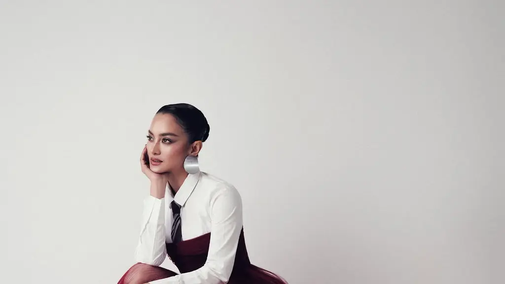 Ririn Ekawati mengenakan kemeja putih klasik yang dipadukan dengan dasi bergaris bernuansa netral. [@ririnekawati].