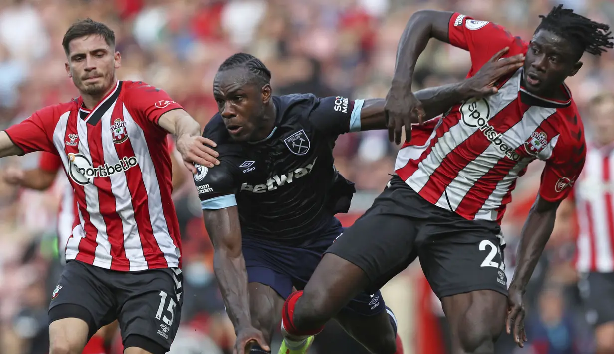 Michail Antonio (tengah) berhasil mencetak empat gol dan tiga assist di tiga laga awal Liga Inggris. Sayangya, Antonio harus diganjar kartu merah kala West Ham menghadapi Southampton. Ia diganjar kartu kuning kedua setelah melakukan tekel tinggi kepada Mousa Djenepo. (Foto: PA via AP/Kieran Cleeves)