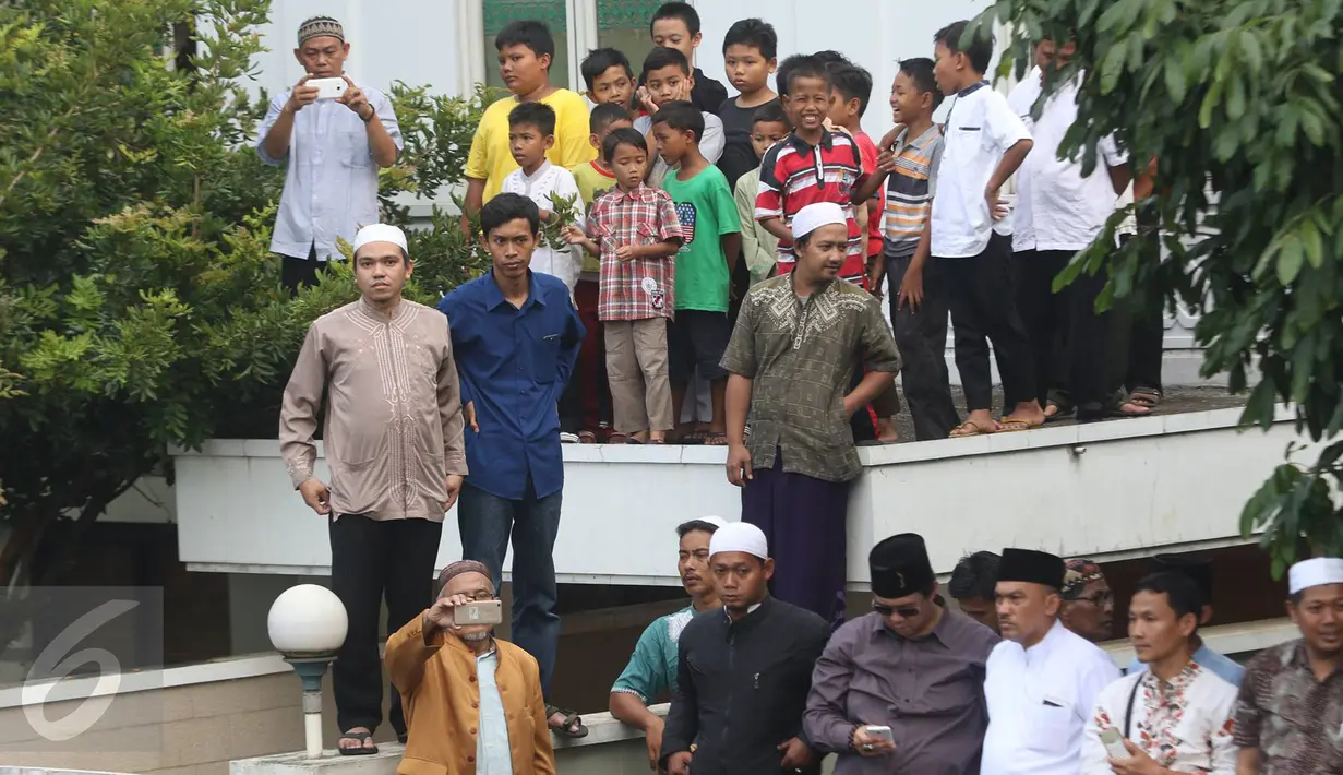 Warga menyaksikan prosesi pemakaman jenazah tokoh PBNU KH Hasyim Muzadi di Pondok Pesantren Al Hikam, Beji, Depok, Kamis (16/3). Mantan Ketua PBNU KH Hasyim Muzadi, tutup usia pada Kamis (16/3/2017). (Liputan6.com/Immanuel Antonius)
