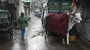 Warga berjalan melewati seekor sapi yang ditutupi selimut di sebuah gang di New Delhi, India, Selasa (5/1/2021). Hal tersebut untuk melindungi sapi agar tetap hangat selama bulan-bulan musim dingin. (Photo by Sajjad HUSSAIN / AFP)
