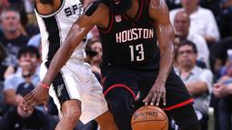 Pebasket Houston Rockets, James Harden, berusaha melewati pebasket San Antonio Spurs, Patty Mills, pada laga semifinal wilayah barat NBA di AT&T Center, San Antonio, Rabu (3/5/2017). Spurs menang 121-96 atas Rockets. (AFP/Ronald Martinez)