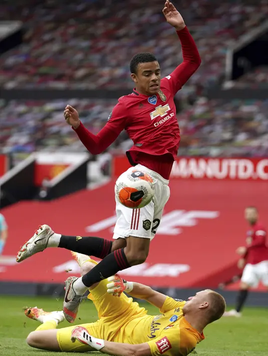 Pemain Manchester United Mason Greenwood (atas) berebut bola dengan kiper Bournemouth Aaron Ramsdale pada pertandingan Premier League di Stadion Old Trafford, Manchester, Inggris, Sabtu (4/7/2020). Manchester United menang 5-2 atas Bournemouth. (Dave Thompson/Pool via AP)