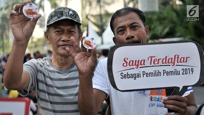 Warga menunjukan pin anti golput usai melakukan pendaftaran daftar pemilih tetap (DPT) di kawasan Car Free Day, Jakarta, Minggu (21/10). Pos pendaftaran ini bertujuan mendata warga yang belum terdaftar dalam DPT Pemilu 2019. (Merdeka.com/Iqbal S. Nugroho)
