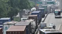 Kemacetan arus kendaraan saat melintas di Jalan Yos Sudarso arah Pelabuhan Tanjung Priok, Jakarta, Kamis (12/7). Kemacetan panjang kendaraan yang didominasi truk kontainer jadi pemandangan rutin di Tanjung Priok. (Merdeka.com/Iqbal S. Nugroho)