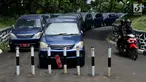 Pengendara motor melintasi deretan mobil dinas yang terparkir di area belakang Gedung DPR/MPR, Jakarta, Selasa (5/12). Mobil-mobil berplat merah tersebut dibiarkan mangkrak hingga berkarat lantaran menunggu proses lelang. (Liputan6.com/Johan Tallo)