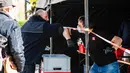 Seorang staf perusahaan katering (kiri) melakukan salam siku dengan seorang pria yang datang untuk mendapatkan makanan gratis di Berlin, ibu kota Jerman (16/4/2020). (Xinhua/Binh Truong)