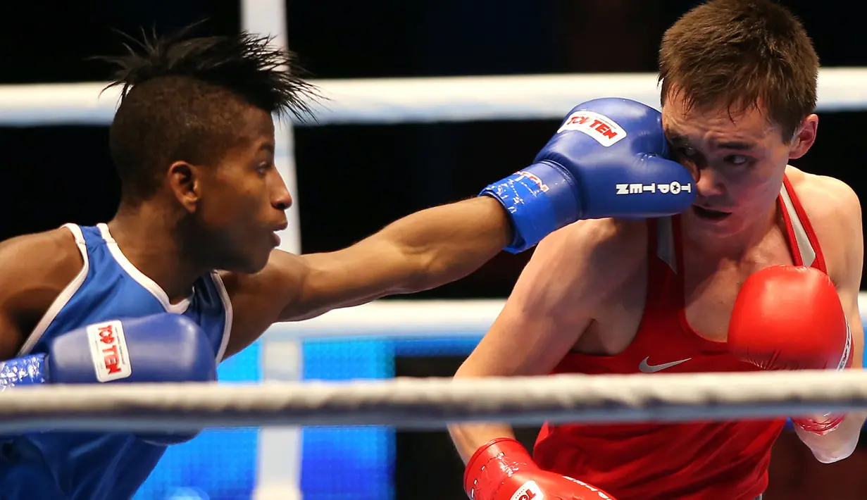 Petinju Kuba, Michael Joahnys Argilagos memukul petinju Rusia, Vasilii Egorov pada laga AIBA World Boxing Championship di Doha, Qatar, Rabu (14/10/2015). (AFP Photo/Faisal Al-Tamimi)