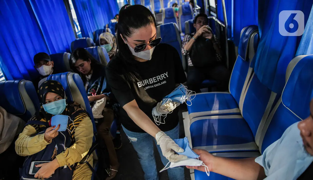 Relawan membagikan masker kepada penumpang bus di Bundaran HI, Jakarta, Selasa (17/3/2020). Sebanyak 3.000 masker dibagikan gratis kepada pengguna jalan sebagai salah satu bentuk keprihatinan sekaligus berpartisipasi dalam upaya mencegah penyebaran virus corona COVID-19. (Liputan6.com/Faizal Fanani)