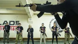 Seorang instruktur menunjukkan cara menggunakan senjata kepada sekelompok wanita selama pelatihan di Kharkiv, Ukraina (30/1/2022). Kharkiv hanya berjarak 40 kilometer (25 mil) dari puluhan ribu tentara Rusia yang berkumpul di perbatasan. (AP Photo/Evgeniy Maloletka)