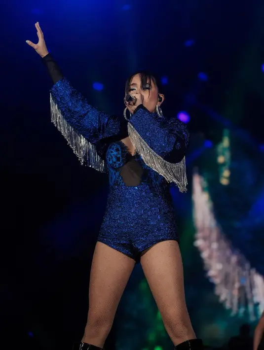 <p>Tampil lebih nyentrik dan glamor, Niki mengenakan bodysuit berwarna biru. Hiasan silver fringe pada lengannya membuat busana panggungnya terlihat totalitas. [Instagram/nikizefanya]</p>