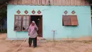 Ragaia Sosir berdiri di depan rumahnya di Kampung Arar, Sorong, Papua Barat Daya. Dari hasil usaha yang dijalankan, ia menyisihkan penghasilan secara bertahap untuk memperbaiki rumah dan memenuhi kebutuhan keluarga. (Sumber: Liputan6.com)