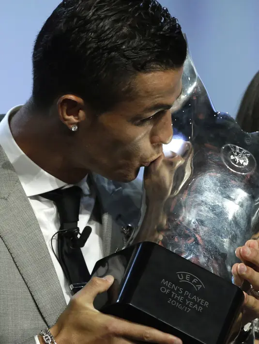 Bintang Madrid, Cristiano Ronaldo mencium trofi Pemain Terbaik Eropa 2017 di Grimaldi Forum, Monaco, (24/8/2017). Ronaldo mengalahkan Messi dan Buffon yang termasuk dalam nominasi. (AP/Claude Paris)