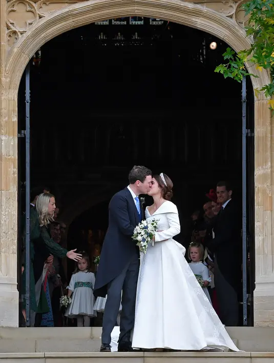 Putri Eugenie dan Jack Brooksbank berciuman usai melangsungkan pernikahan di Kapel St. George, Windsor Castle, London, Inggris, Jumat (12/10). Awal tahun 2018, Pangeran Harry dan Meghan Markle juga menikah di kapel ini. (Toby Melville, Pool via AP)