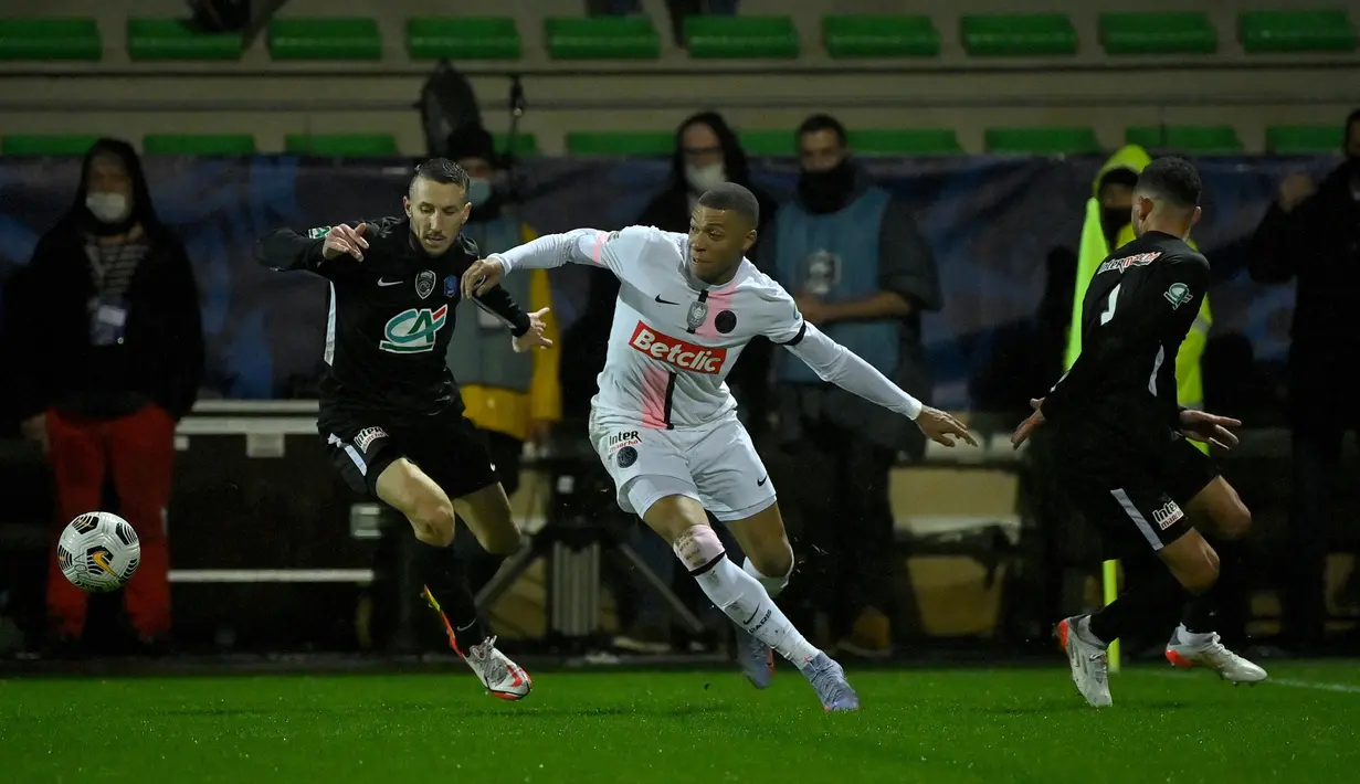 Penyerang Paris Saint-Germain (PSG) Kylian Mbappe berebut bola dengan penyerang klub divisi empat, Vannes OC, Sebastien Persico dalam babak 32 besar Piala Prancis di Stade de la Rabine, Selasa (4/1/2021) dini hari WIB. PSG menang 4-0 lewat hattrick Kylian Mbappe. (LOIC VENANCE/AFP)