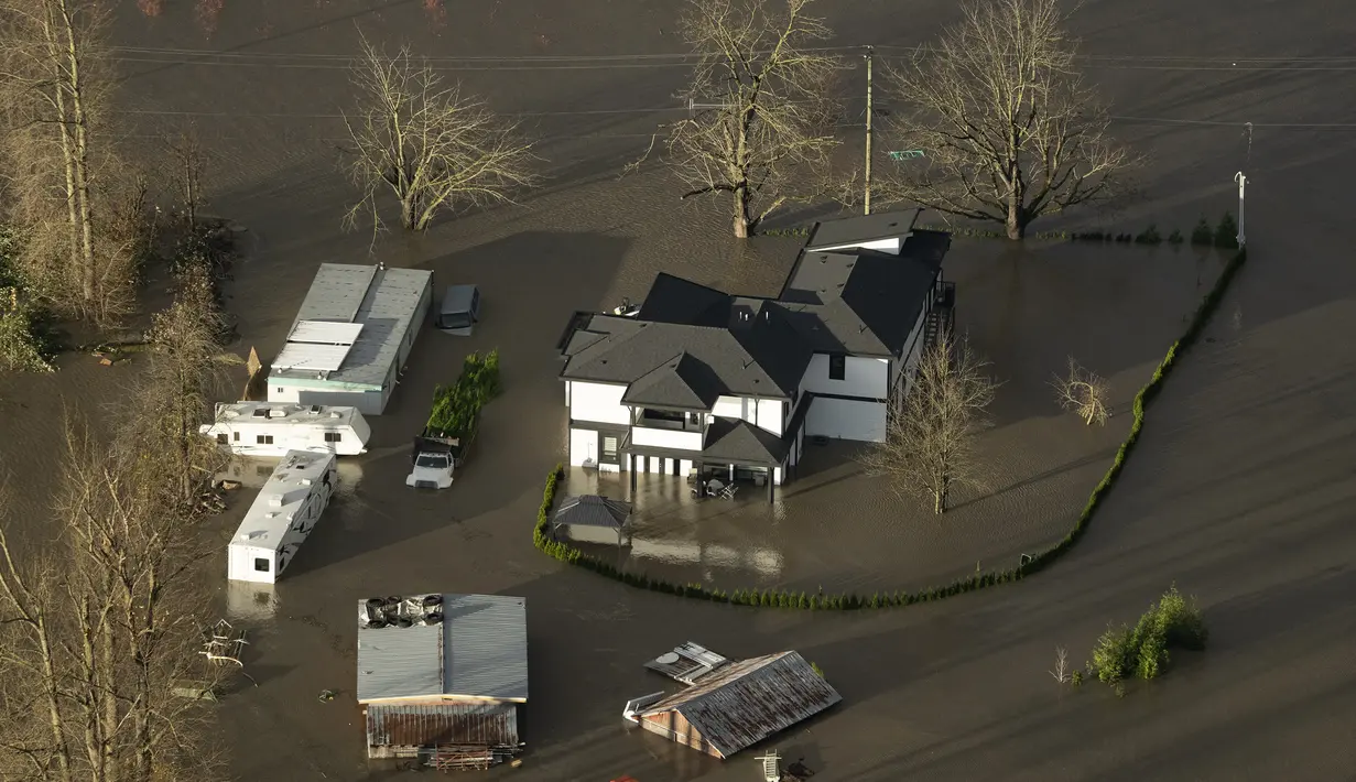 Banjir menggenangi sebuah rumah di Abbotsford, British Columbia, Kanada, Selasa (16/11/2021). Banjir juga telah menutup banyak jalan raya, termasuk semua rute utama ke Vancouver. (Jonathan Hayward/The Canadian Press via AP)