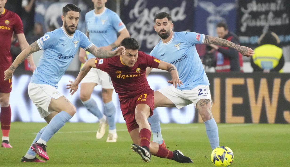 Pemain AS Roma, Paulo Dybala, berusaha melewati adangan pemain Lazio pada laga pekan ke-27 Serie A 2022/2023 di Stadion Olimpico, Senin (20/03/2023). Lazio menang dengan skor 1-0. (AP Photo/Gregorio Borgia)