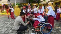 Salah satu siswa didampingi personel Direktorat Polisi Satwa (Ditpolsatwa) berinteraksi dengan anjing pelacak K-9 di Sekolah Luar Biasa Negeri (SLBN) kota Depok, Jawa Barat, Senin (2/6/2025). (merdeka.com/Arie Basuki)
