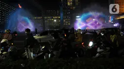 Pemprov DKI Jakarta menggelar perayaan malam tahun baru 2024 di Bundaran HI dengan menampilkan pertunjukan water screen, atraksi drone, dan video mapping. (merdeka.com/Imam Buhori)