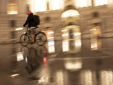 Seorang pengendara sepeda melewati istana Hofburg di alun-alun Michaeler di Wina, Austria, Senin (22/11/2021). Austria kembali menerapkan lockdown penuh untuk mengekang infeksi Covid-19 menyebar ke seluruh Eropa. (JOE KLAMAR / AFP)