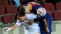 Bek Barcelona, Gerard Pique, berebut bola dengan gelandang Ferencvaros, Oleksandr Zubkov, pada matchday 1 Grup G Liga Champions 2020/2021 di Camp Nou, Rabu (21/10/2020) dini hari WIB. Barcelona menang 5-1 atas Ferencvaros. (AFP/Lluis Gene)