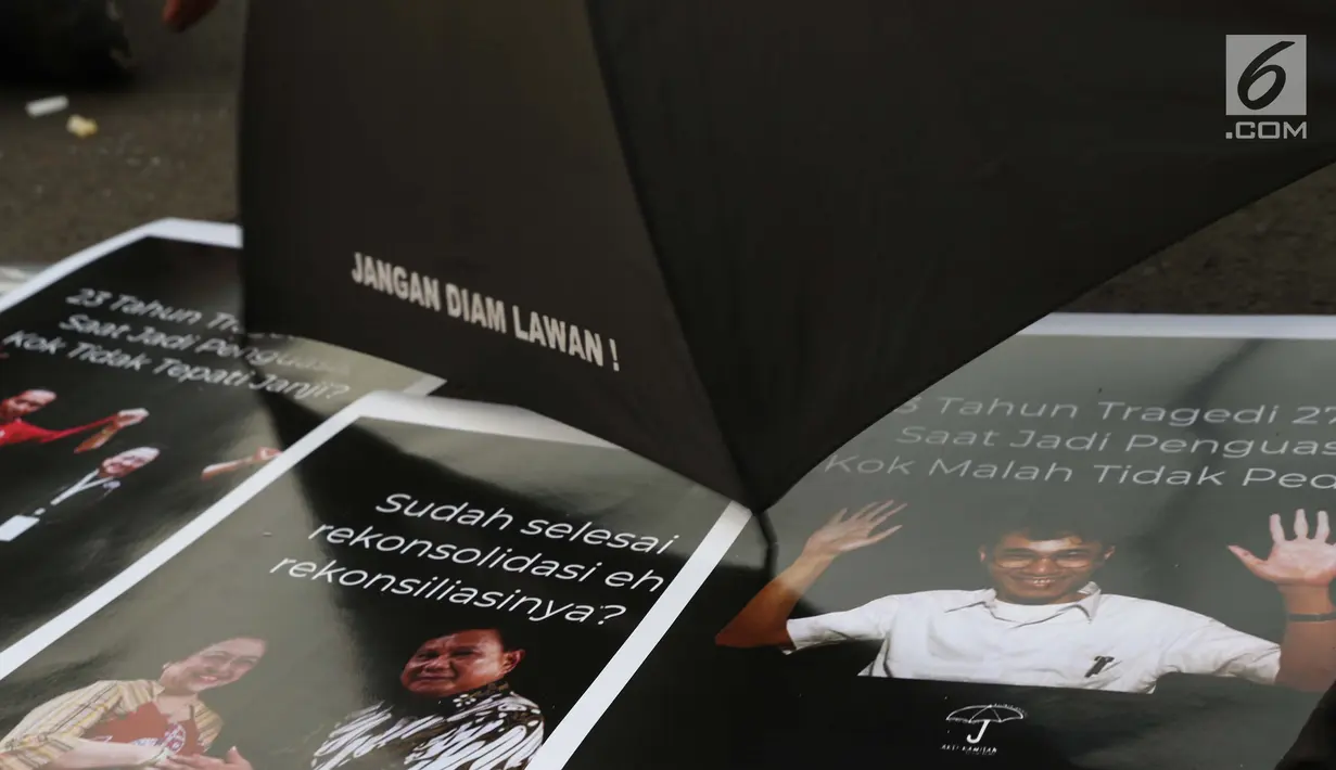 Aktivis yang tergabung dalam Jaringan Solidaritas Korban untuk Keadilan mengambil poster saat aksi Kamisan di depan Istana Negara, Jakarta, Kamis (25/7/2019). Aksi Kamisan ke-594 mengangkat tema '23 Tahun Tragedi 27 Juli Saat Jadi Penguasa Kok Malah Tidak Peduli?'. (Liputan6.com/Helmi Fithriansyah)