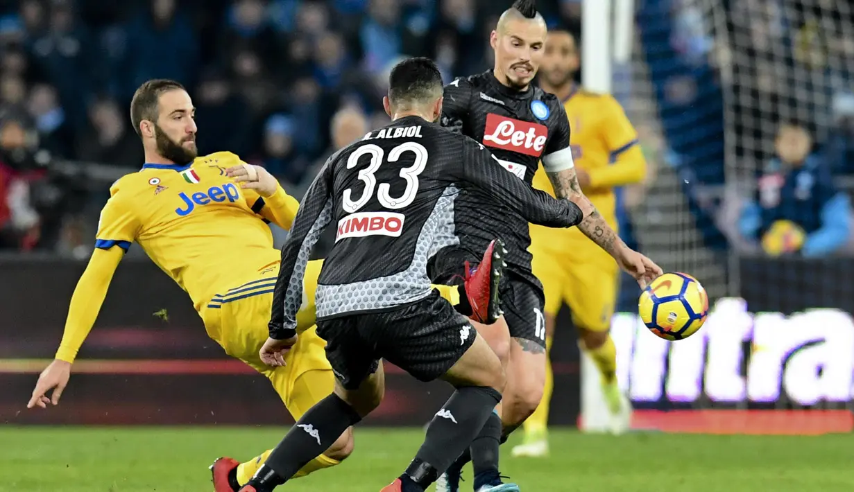 Aksi pemain Juventus, Gonzalo Higuain melakukan tembakan melewati dua pemain Napoli pada lanjutan Serie A Italia di San Paolo stadium, Naples, (1/12/2017). Juventus menang 1-0 atas Napoli. (Ciro Fusco/ANSA via AP)