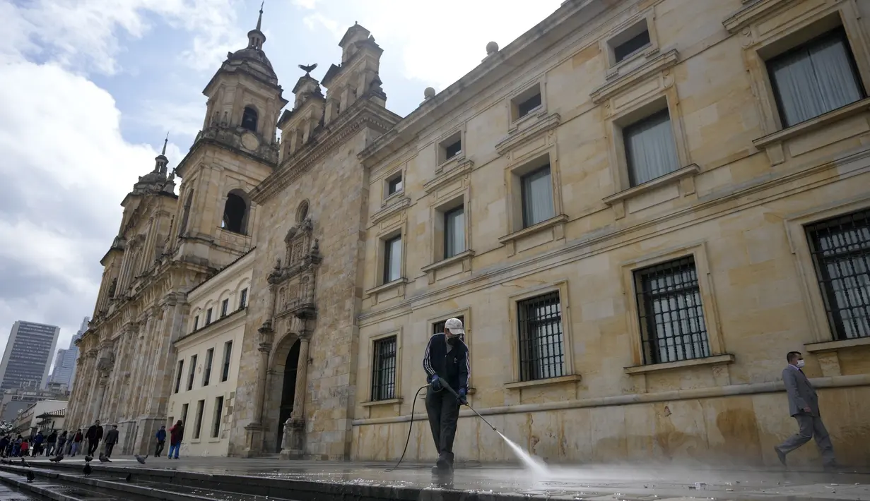 Seorang pekerja membersihkan trotoar di luar Katedral menjelang upacara pelantikan presiden di Bogota, Kolombia, Kamis, 4 Agustus 2022. Gustavo Petro akan menggantikan Iván Duque Márquez sebagai presiden Kolombia. (AP Photo/Fernando Vergara)