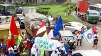 Sejumlah buruh memblokir kawasan jalan tol saat berunjuk rasa menuntut kenaikan Upah Minimum Kabupaten/Kota di pintu Tol Bitung, Tangerang, Banten. (Antara)