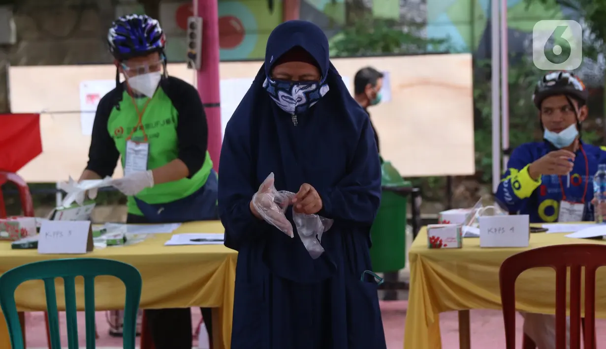 Pemiilih mengenakan sarung tangan plastik saat menggunakan hak suaranya dalam Pilkada Tangerang Selatan di TPS 23 Pondok Jagung Timur, Rabu (9/12/2020). Menggunakan masker hingga memakai sarung tangan plastik menjadi hal wajib saat melakukan pencoblosan di Pilkada 2020. (Liputan6.com/Angga Yuniar)