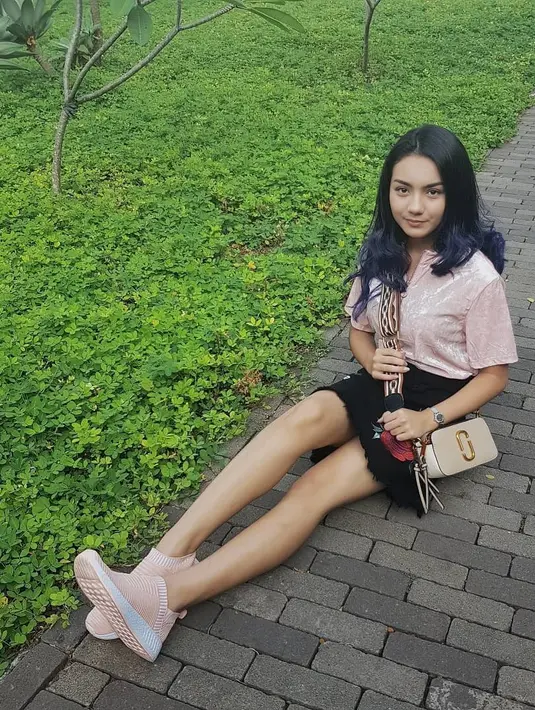 Paduan nuansa sporty dan girly sering hadir di gaya busana Ersya. Coba lihat, ia memakai mini skirt hitam, kaus pink dan tetap dipadukannya dengan sneakers. (Instagram/ersyaurel)
