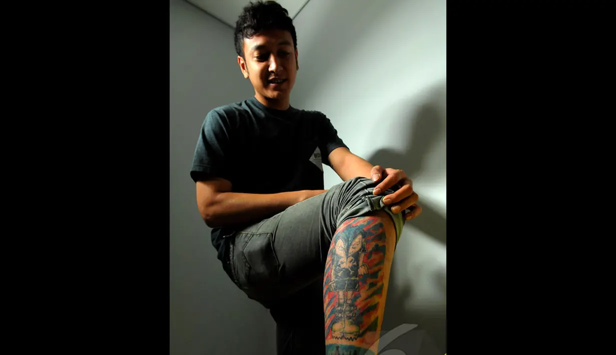 Tato bergambar kepulauan Indonesia dan sebuah kartun diperlihatkan Dimas di kaki kanannya, Jakarta, Senin (16/6/2014) (Liputan6.com/Faisal R Syam)
