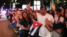Sejumlah warga Kuba bersorak merayakan wafatnya Fidel Castro di Miami, AS (26/11). Mereka bahagia dan merayakan setelah menunggu bertahun-tahun meninggalnya pemimpin revolusi komunis Kuba Fidel Castro. (REUTERS/Javier Galeano)