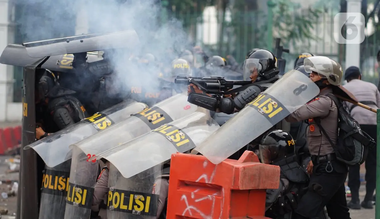 Polisi menembakkan gas air mata saat terlibat bentrok dengan pengunjuk rasa di Jalan Medan Merdeka Timur, Jakarta, Kamis (8/10/2020). Bentrokan terjadi akibat massa yang memaksa masuk ke depan Istana Negara untuk berunjuk rasa terkait penolakan UU Cipta Kerja. (Liputan6.com/Immanuel Antonius)