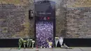 Bunga, lilin, gambar dan bendera dengan pesan ditinggalkan di luar rumah mendiang Freddie Mercury, pada peringatan 30 tahun kematiannya, di London, Rabu (24/11/2021). Freddie Mercury, penyanyi yang juga pentolan grup band Queen  meninggal dunia pada 24 November 1991. (AP Photo/Alberto Pezzali)
