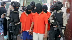 Polisi menggiring tersangka kasus begal di Mapolres Metro Jakarta Selatan, Selasa (17/7). Polisi mengamankan barang bukti sebilah pedang, sebilah pisau, telepon selular, dan dua unit sepeda motor. (Liputan6.com/Immanuel Antonius)