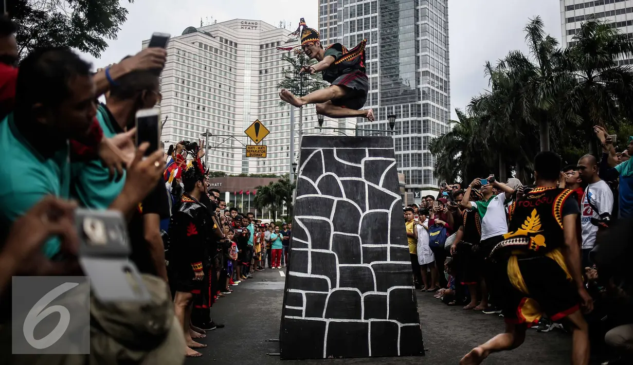 Seorang pria melakukan fahombo di sebuah acara pagelaran seni dan kebudayaan Nias di Jalan Imam Bonjol, Jakarta, Minggu (12/2). Acara ini digelar dalam rangka memperkenalkan kebudayaan Nias kepada para pengunjung Car Free Day. (Liputan6.com/Faizal Fanani)